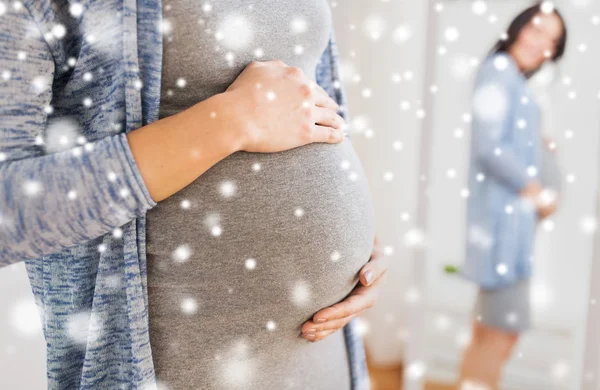 Nahaufnahme einer schwangeren Frau, die in den Spiegel schaut — Stockfoto