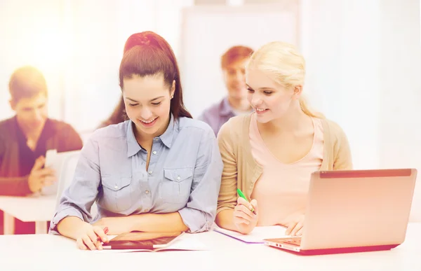 Dos estudiantes sonrientes con ordenador portátil y tableta PC —  Fotos de Stock