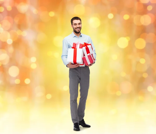 Felice giovane uomo in possesso di scatole regalo — Foto Stock
