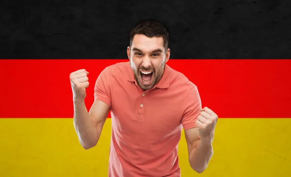 Homem zangado mostrando punhos sobre bandeira alemã — Fotografia de Stock