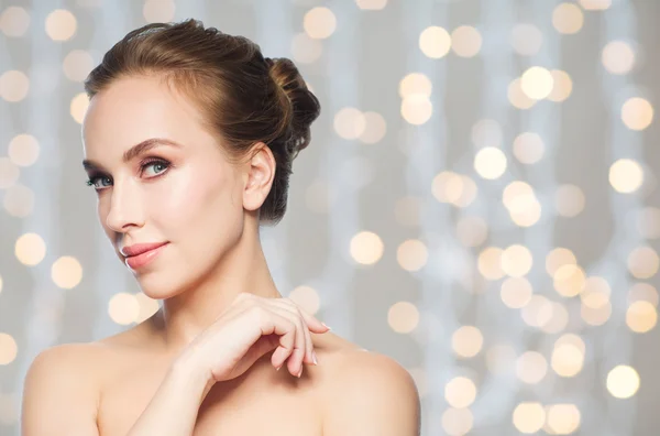 Hermosa cara de mujer joven sobre luces de vacaciones — Foto de Stock