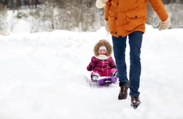 Ojciec ciągnąc sanki z szczęśliwe dziecko w zimie — Zdjęcie stockowe