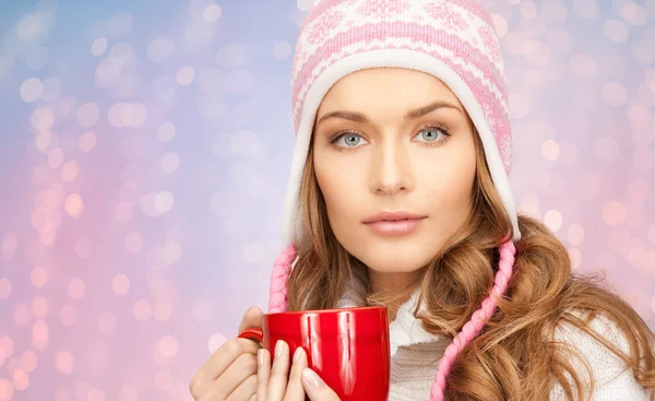 Happy young woman in winter hat with cup of tea — Stock Photo, Image