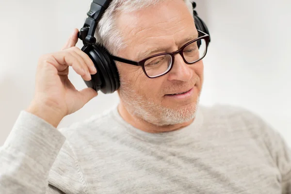 自宅で音楽を聴くヘッドフォンで幸せな男 — ストック写真