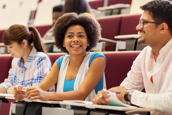 Groupe d'étudiants avec des cahiers dans la salle de conférence — Photo