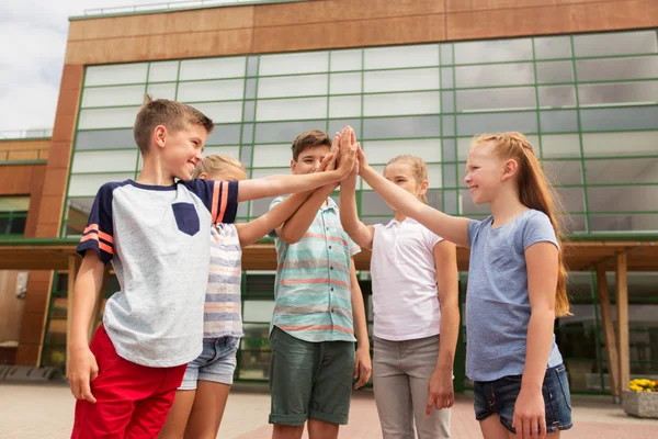 Gruppo di bambini che fanno il cinque al cortile della scuola — Foto Stock