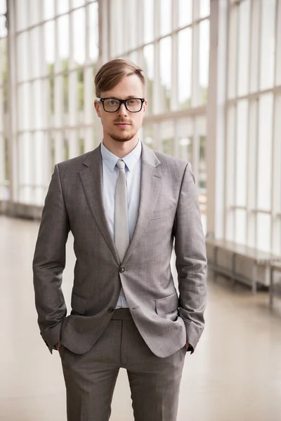 Young businessman in suit and glasses at office — Stock Photo, Image