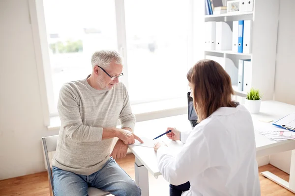 Old man and doctor with prescription at hospital — Stock Photo, Image