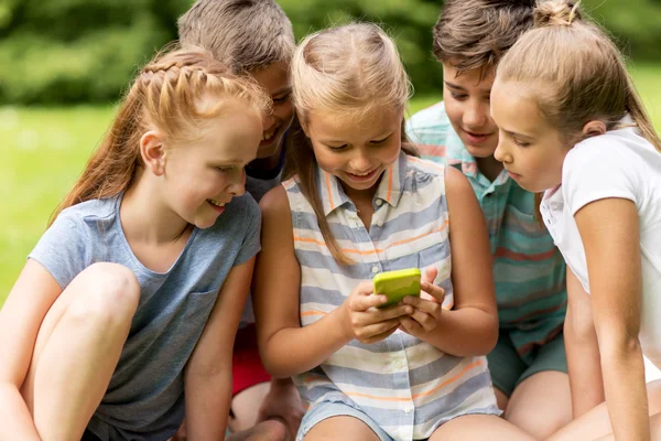 Дети или друзья со смартфоном в летнем парке — стоковое фото