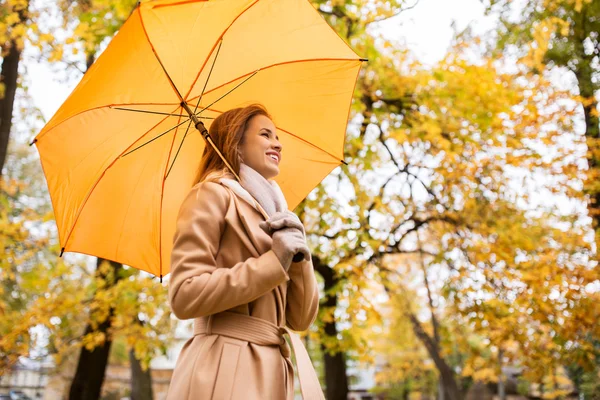 快乐的女人带着雨伞在秋天的公园里散步 — 图库照片