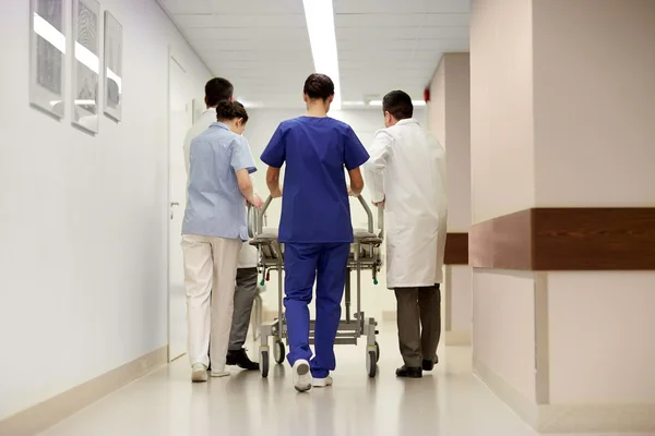 Médicos llevando camilla del hospital a la sala de emergencias —  Fotos de Stock