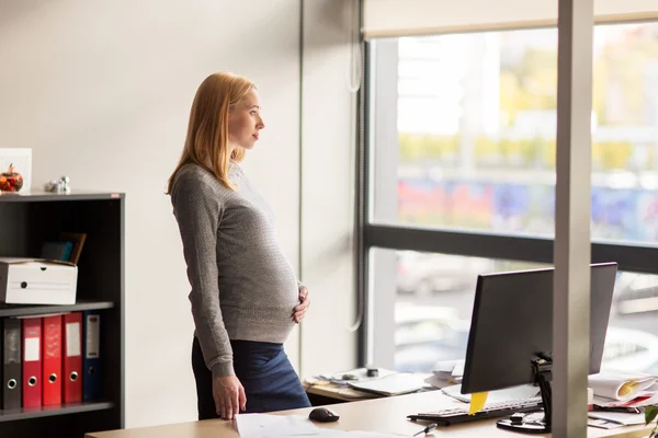 Schwangere Geschäftsfrau mit Computer im Büro — Stockfoto