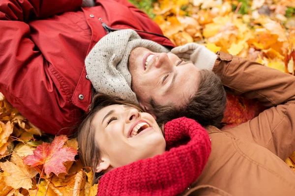 Gros plan du couple souriant couché sur les feuilles d'automne — Photo