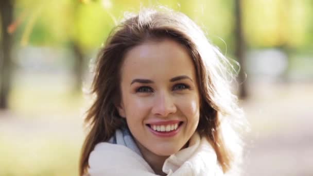 Красивая счастливая молодая женщина улыбается в осеннем парке — стоковое видео