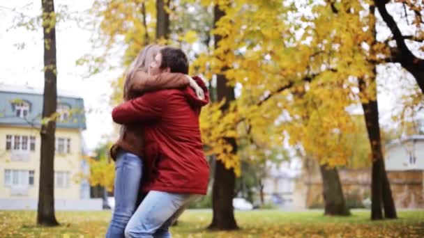 Feliz pareja joven divirtiéndose en el parque de otoño — Vídeo de stock