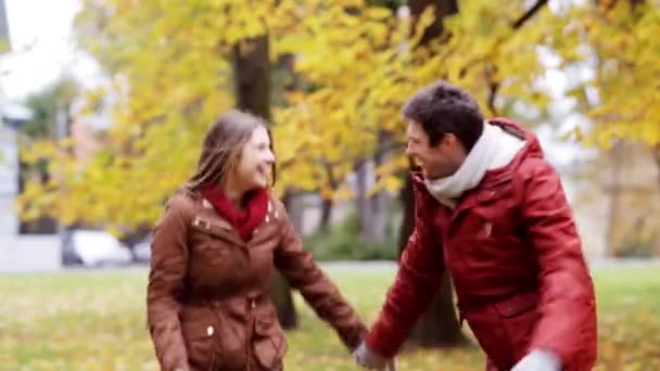 Feliz jovem casal se divertindo no parque de outono — Vídeo de Stock