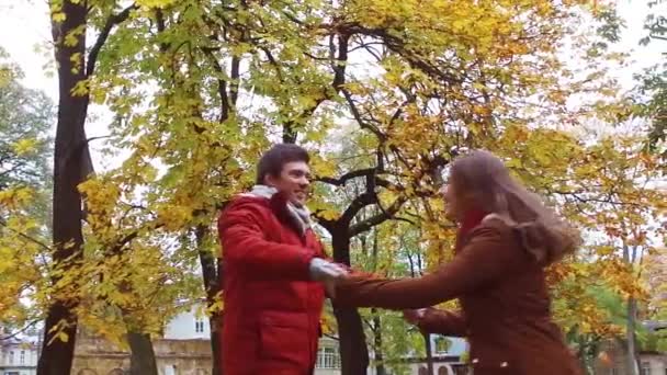 Feliz jovem casal se divertindo no parque de outono — Vídeo de Stock