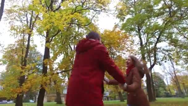 Feliz jovem casal se divertindo no parque de outono — Vídeo de Stock