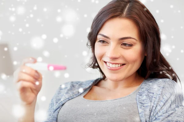 Mujer feliz mirando la prueba de embarazo en casa — Foto de Stock