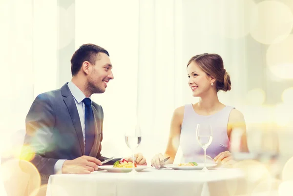 Усміхнена пара їсть основні страви в ресторані — стокове фото
