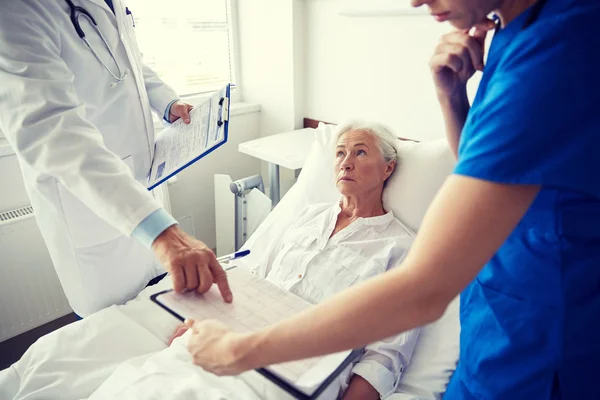 Arzt und Krankenschwester besuchen Seniorin im Krankenhaus — Stockfoto