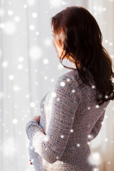 Nahaufnahme einer glücklichen Schwangeren, die zum Fenster blickt — Stockfoto