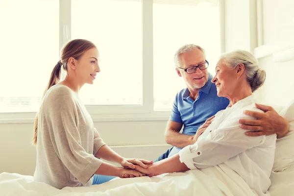 Lycklig familj besöker senior kvinna på sjukhuset — Stockfoto