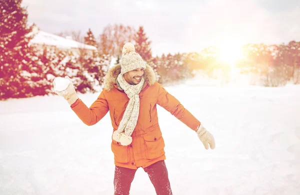 Χαρούμενος νεαρός παίζει χιονόμπαλες το χειμώνα — Φωτογραφία Αρχείου