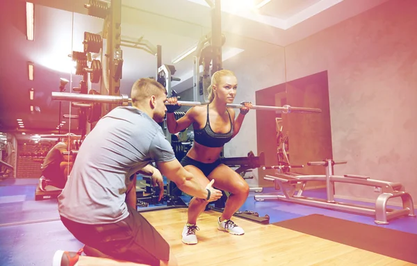 Homme et femme avec bar flexion des muscles dans la salle de gym — Photo