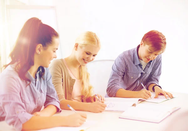 Smiling students with notebooks at school — Stock Photo, Image