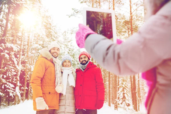 Smiling friends with tablet pc in winter forest — Stock Photo, Image