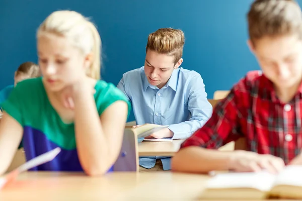 Skupina studentů s knihami psaní školu test — Stock fotografie