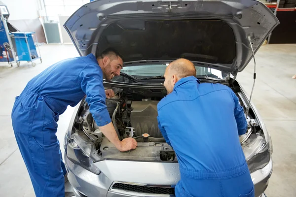 Hombres mecánicos con llave inglesa reparación de coches en el taller — Foto de Stock