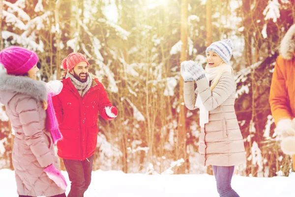 Amigos felizes jogando bola de neve na floresta de inverno — Fotografia de Stock