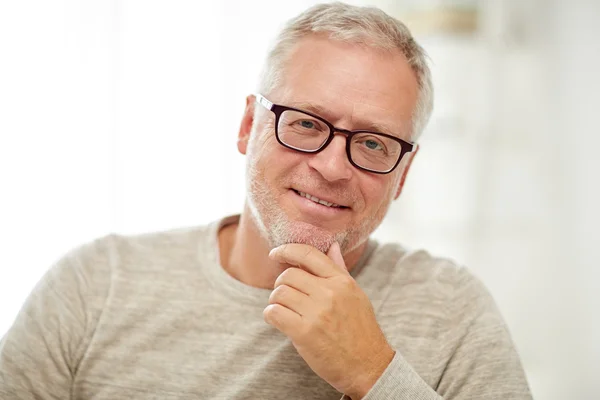 Close up of smiling senior man in glasses thinking — Stock Photo, Image