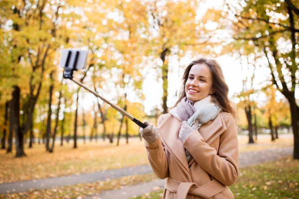 女人以智能手机在秋天公园自拍照 — 图库照片