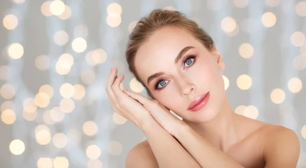 Hermosa cara de mujer y las manos sobre luces — Foto de Stock