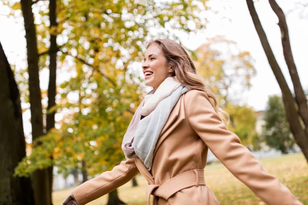 Schöne glückliche junge Frau, die im herbstlichen Park spaziert — Stockfoto