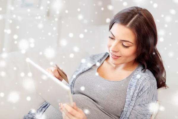 Беременная женщина с планшетным ПК и кредитной картой — стоковое фото