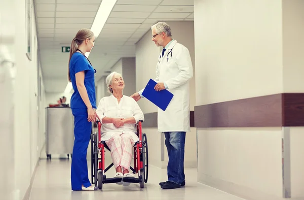 Медики и пожилая женщина в инвалидной коляске в больнице — стоковое фото