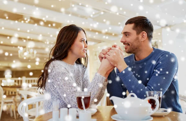 Счастливая пара с чаем, держась за руки в ресторане — стоковое фото