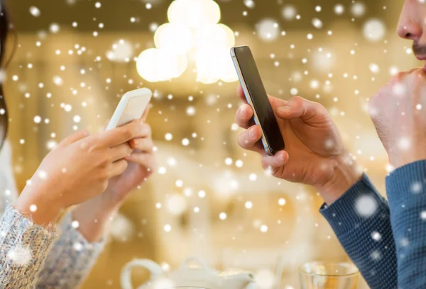 Primer plano de pareja con teléfonos inteligentes en la cafetería —  Fotos de Stock