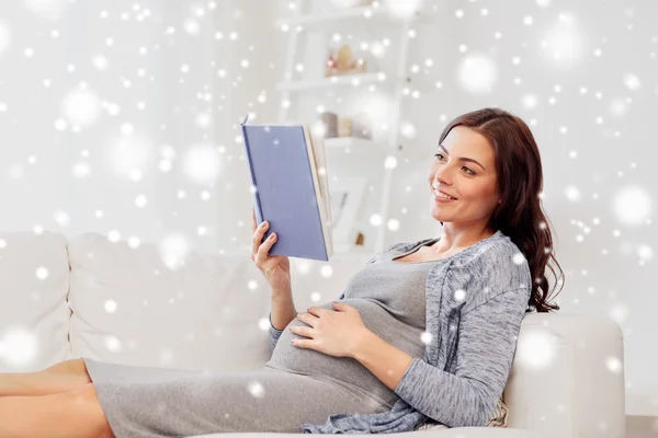 Feliz embarazada leyendo libro en casa — Foto de Stock