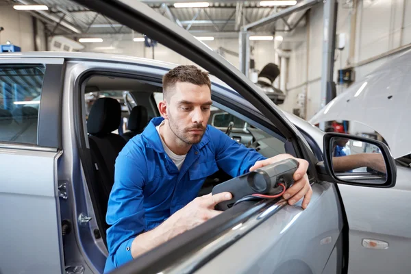 Hombre mecánico con escáner de diagnóstico en el taller de automóviles — Foto de Stock