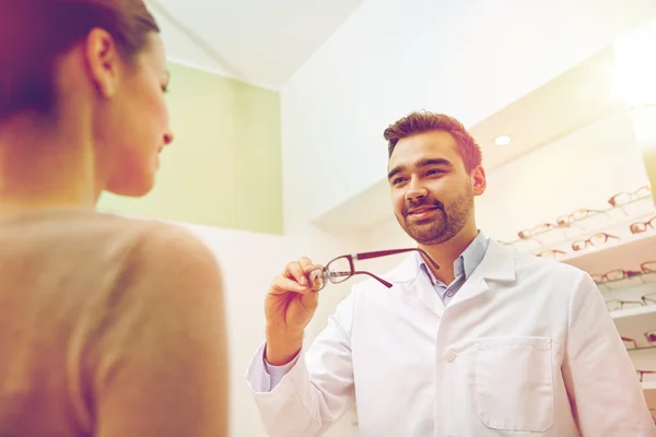 Optiker schenkt Frau Brille im Optikgeschäft — Stockfoto