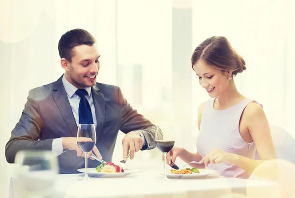 Leende par äter huvudrätt på restaurang Royaltyfria Stockbilder