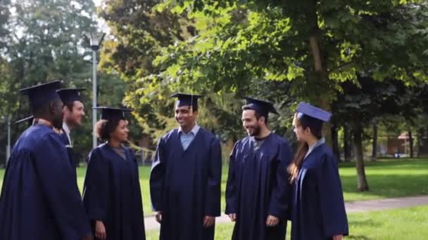 Estudantes felizes jogando placas de argamassa para cima — Vídeo de Stock