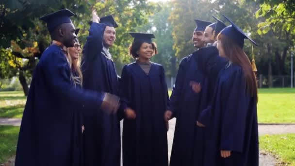 Glada studenter i murbruk styrelser att göra high five — Stockvideo