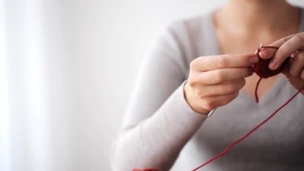 かぎ針編みのフックと赤の糸で編み物をする女 — ストック動画