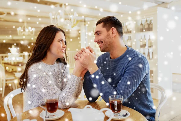 Šťastný pár s čajem drží ruce v restauraci — Stock fotografie